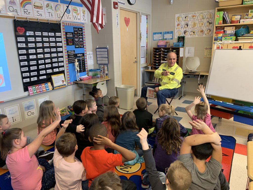 Plant manager Drew Schneider reads to 2nd graders at Niles Primary